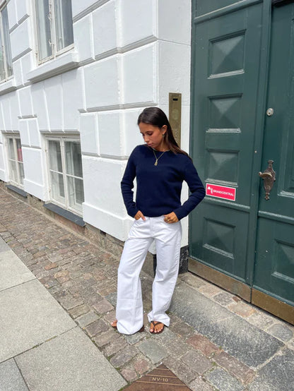 Vue de face du jean blanc avec des étoiles brunes à l'arrière. Coupe droite et ample avec taille mi-haute, passants pour ceinture, fermeture éclair et bouton. Parfait pour un look oversize ou ajusté selon vos préférences.